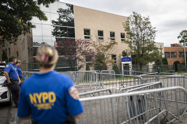 Community affairs officers from the NYPD stand at the barricades outside the former Saint John Villa Academy being repurposed as a shelter for homeless migrants, Wednesday, Sept. 13, 2023, in Staten Island.