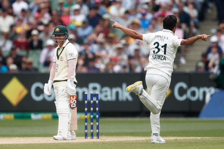 Pakistan bowler Mir Hamza runs past Australia batter David Warner after bowling him at the MCG.
