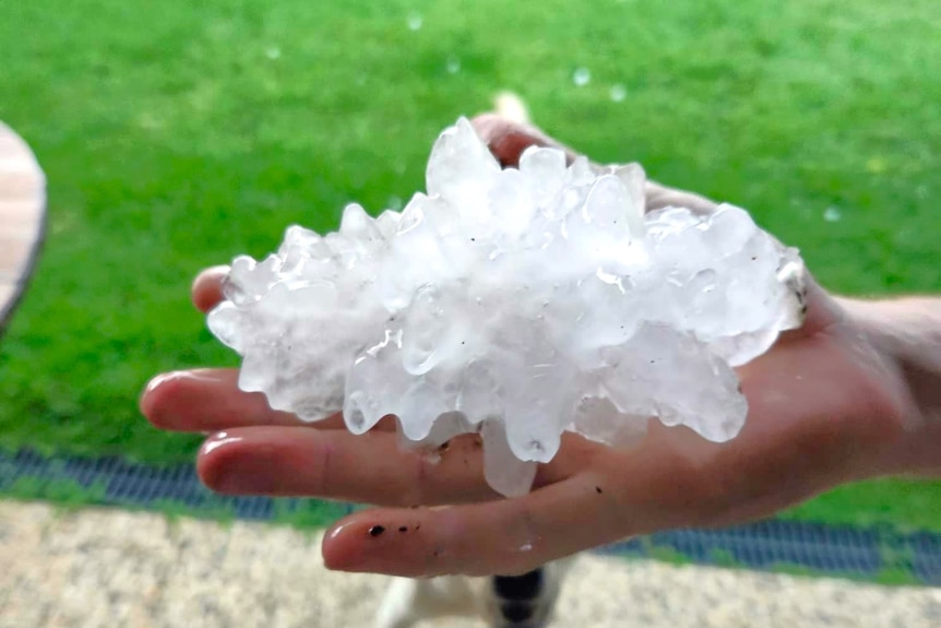 A large hailstone being held in a person's hand.