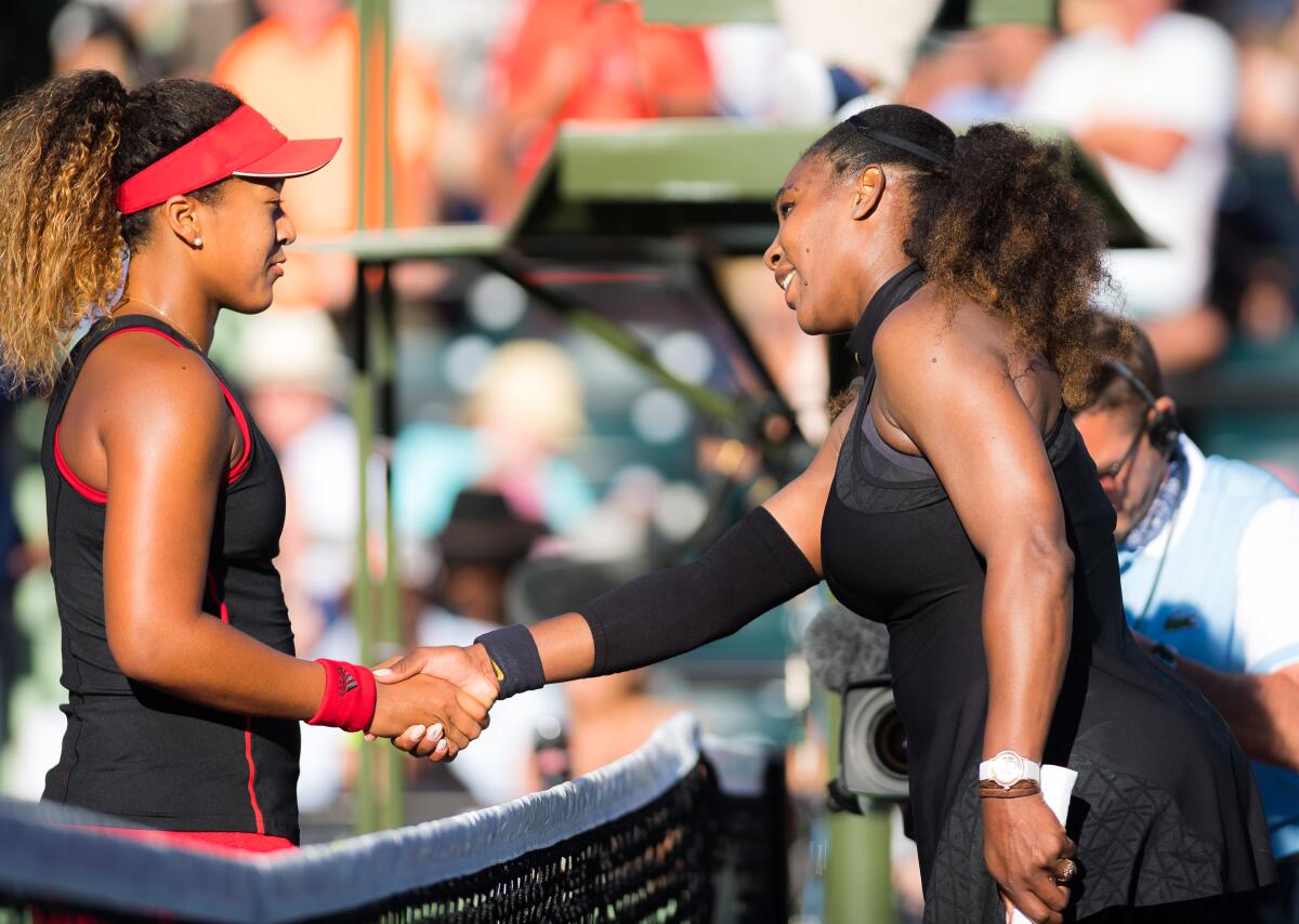 Victorious Naomi Osaka shakes hands with Serena Williams after their first match in Miami, 2018.
