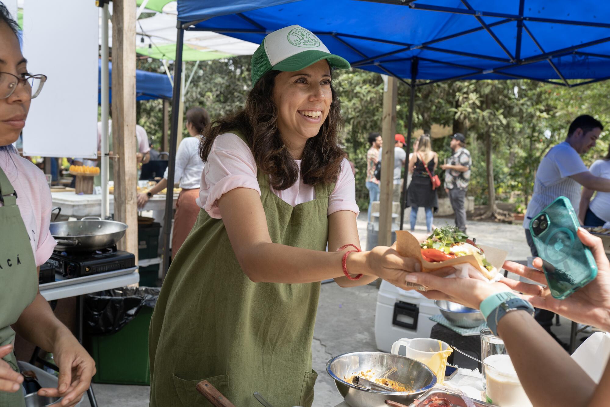ANTIGUA, GUATEMALA - APRIL 29, 2023: Chef Debora Fadul serves a customer at the 6 Chefs festival in Antigua.