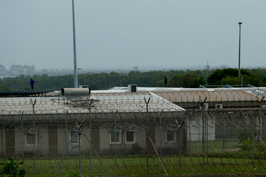 Youth detainees on roof of prison behind barbed wire