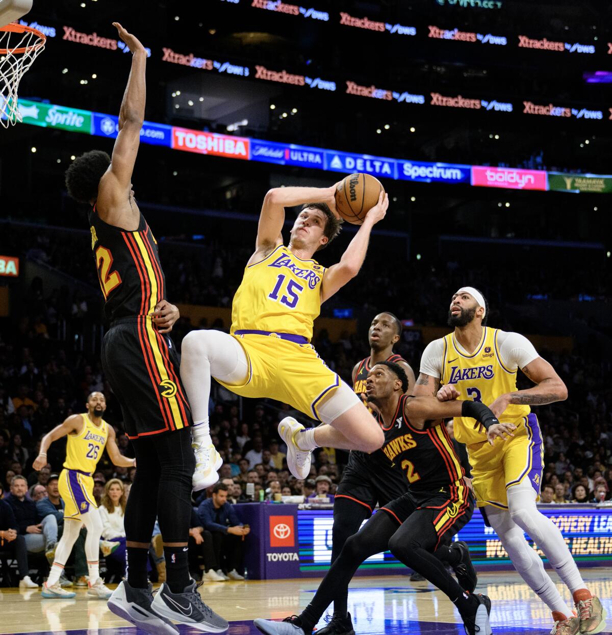 Lakers guard Austin Reaves makes a midair pass in front of Atlanta Hawks forward De'Andre Hunter.