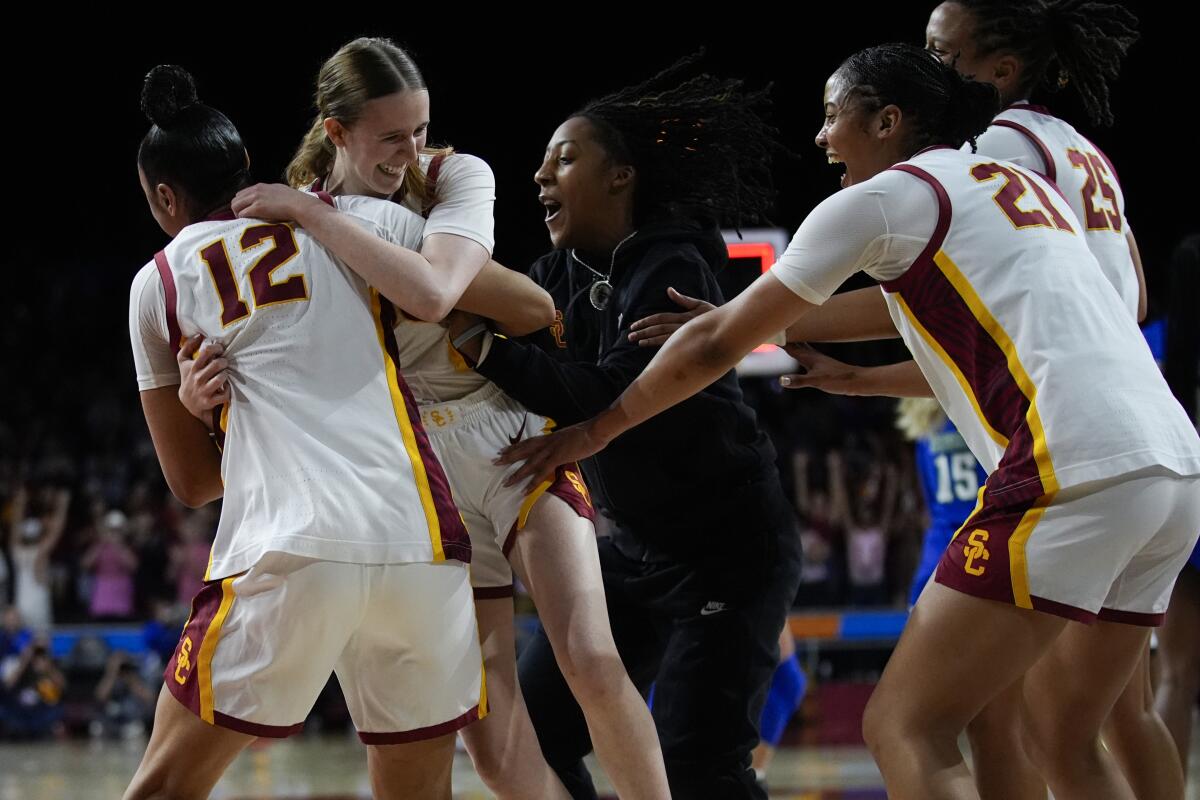 USC guard India Otto, center left, celebrates with guard JuJu Watkins after the Trojans' win.