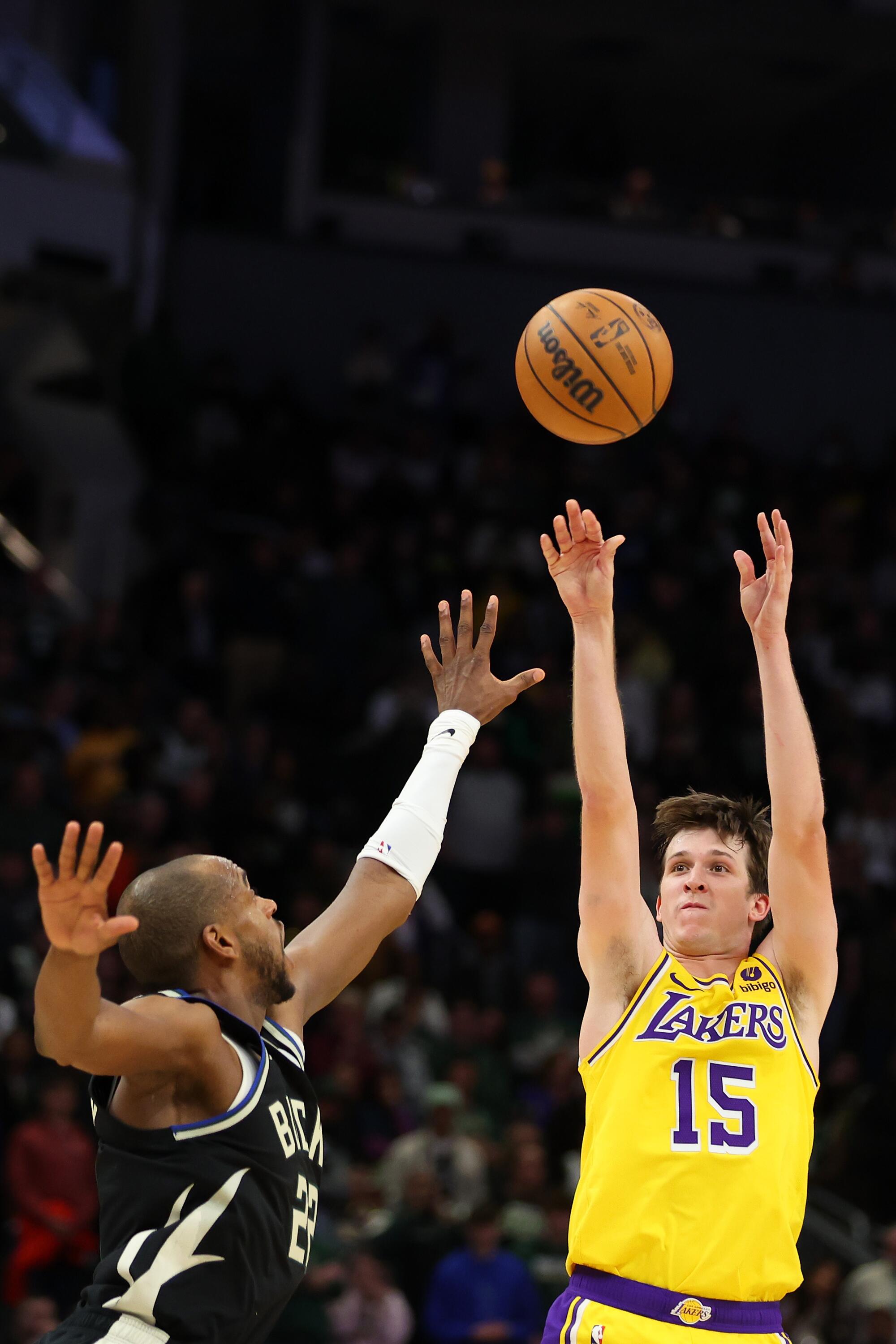 The Lakers' Austin Reaves shoots over the Bucks' Khris Middleton during the second overtime of the Lakers' win