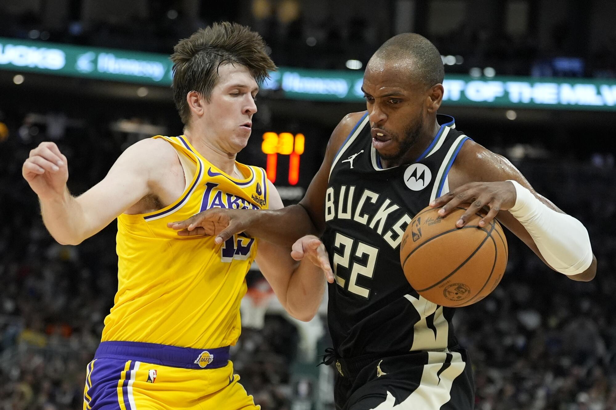 The Bucks' Khris Middleton tries to get past the Lakers' Austin Reaves Tuesday in Milwaukee. 