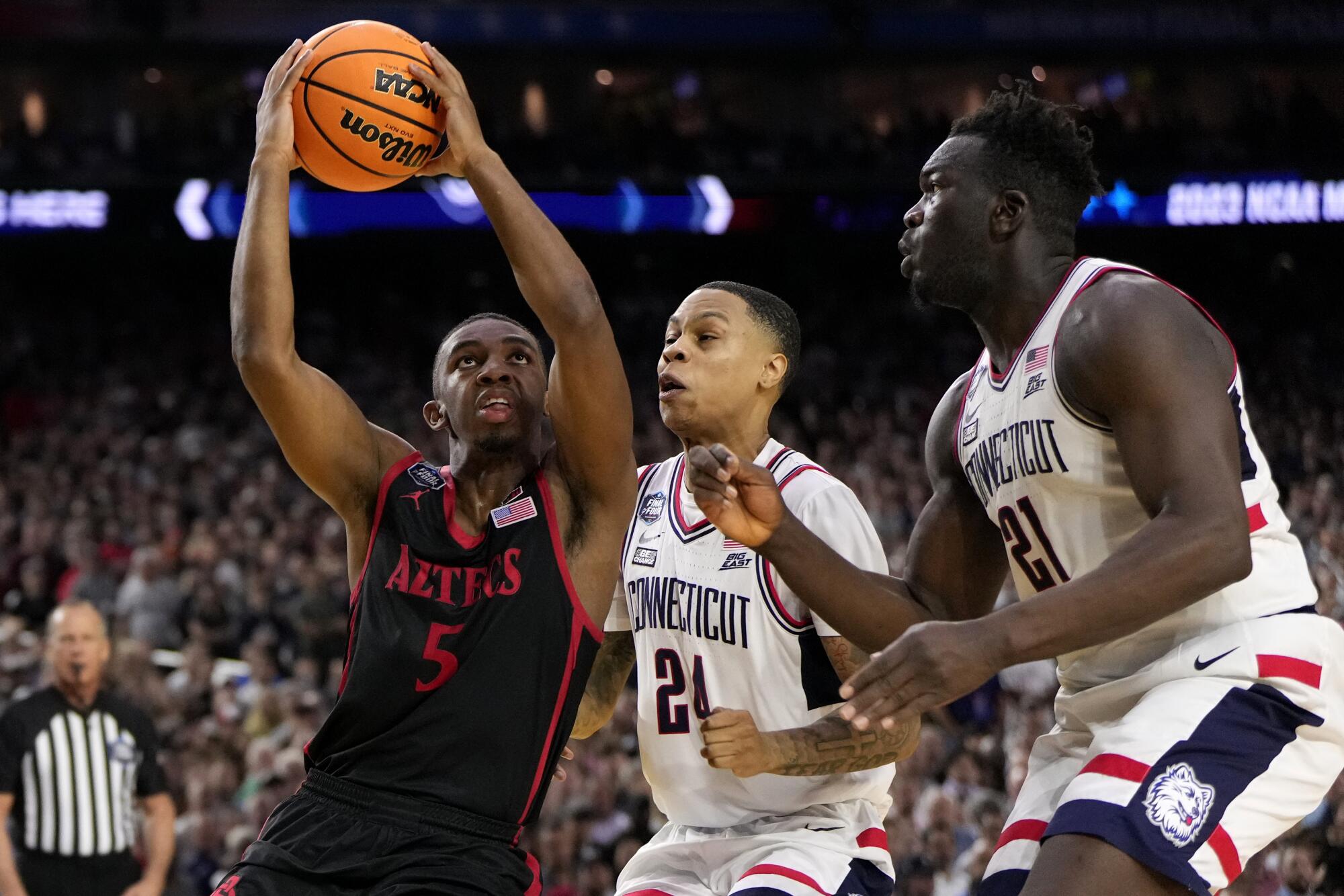 San Diego State guard Lamont Butler drives as UConn guard Jordan Hawkins defends during the 2023 national championship