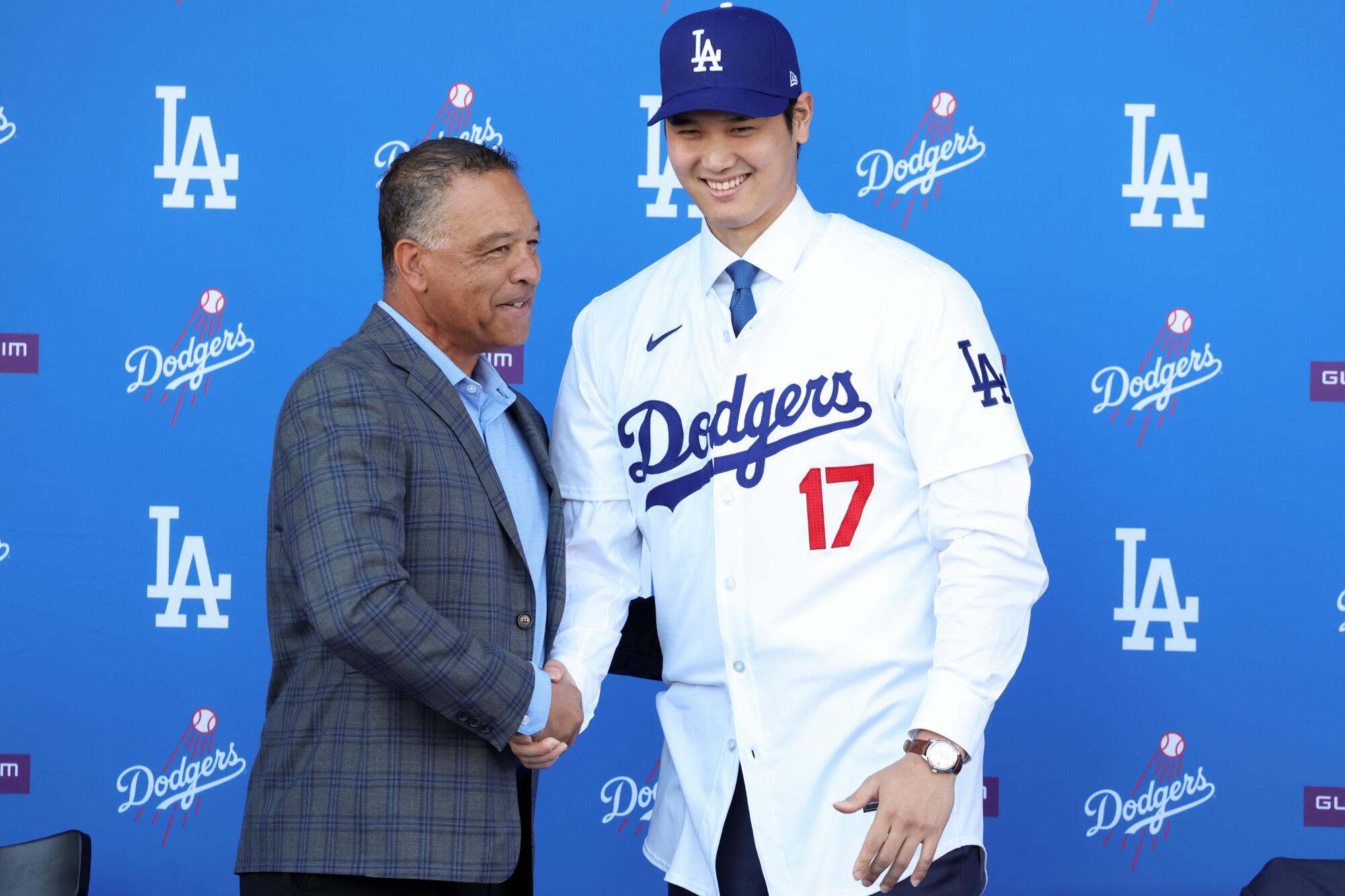 Dodgers manager Dave Roberts, left, shakes hands with Shohei Ohtani on Dec. 14, 2023.