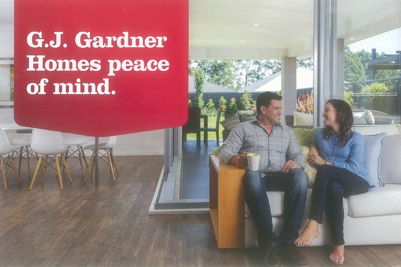 A couple sits on a couch in a brochure image
