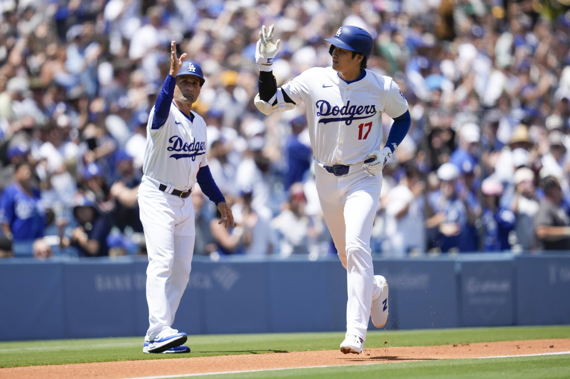 Shohei Ohtani runs past Dodgers third base coach Dino Ebel after hitting a home run in the first inning Sunday.