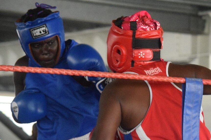 Two female boxers from Papua New Guinea exchange blows during a fight.