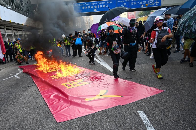 Protesters burn a sign celebrating the 70th anniversary of China during an anti-government rally in Hong Kong on Oct. 1, 2019. On Thursday, a court in Hong Kong convicted 14 pro-democracy protesters on sedition charges. Photo by Thomas Maresca/UPI