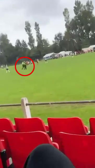Two police officers are seen walking across the pitch