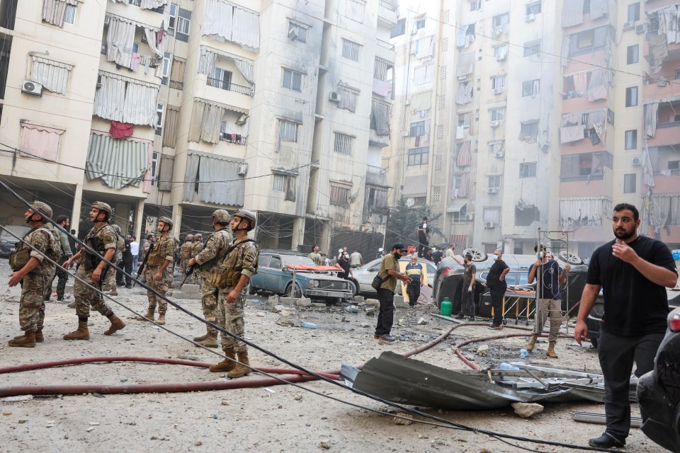 Residents and the military assess the damage to an apartment block in the southern suburbs of Beirut, Lebanon
