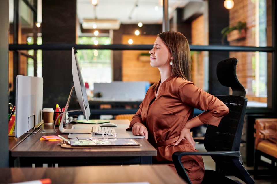 Office workers face poor posture due to how they sit at their desks as well as long commutes with heavy bags (stock image)