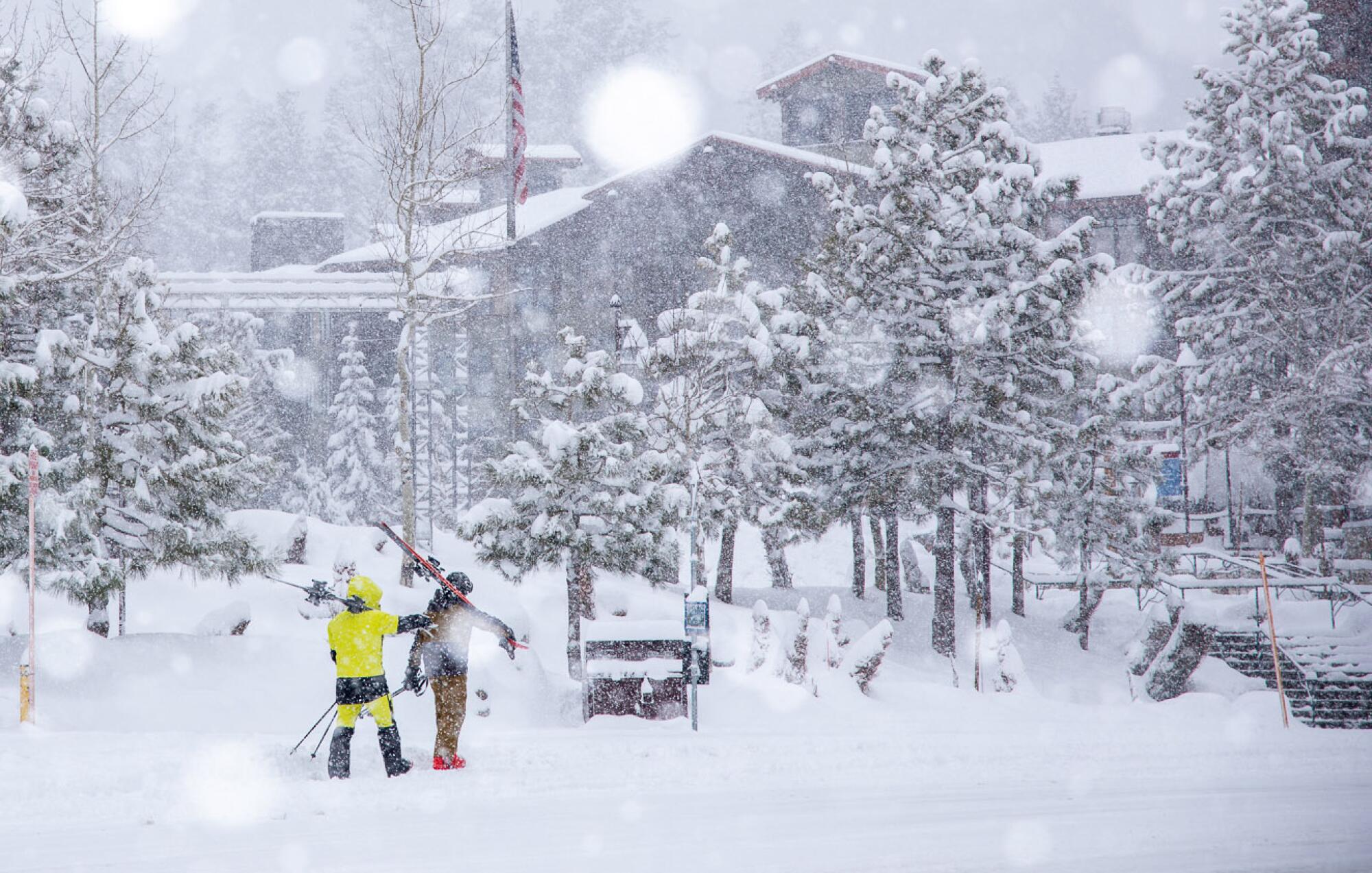 Skiers walking by the lodge at Mammoth Mountain.
