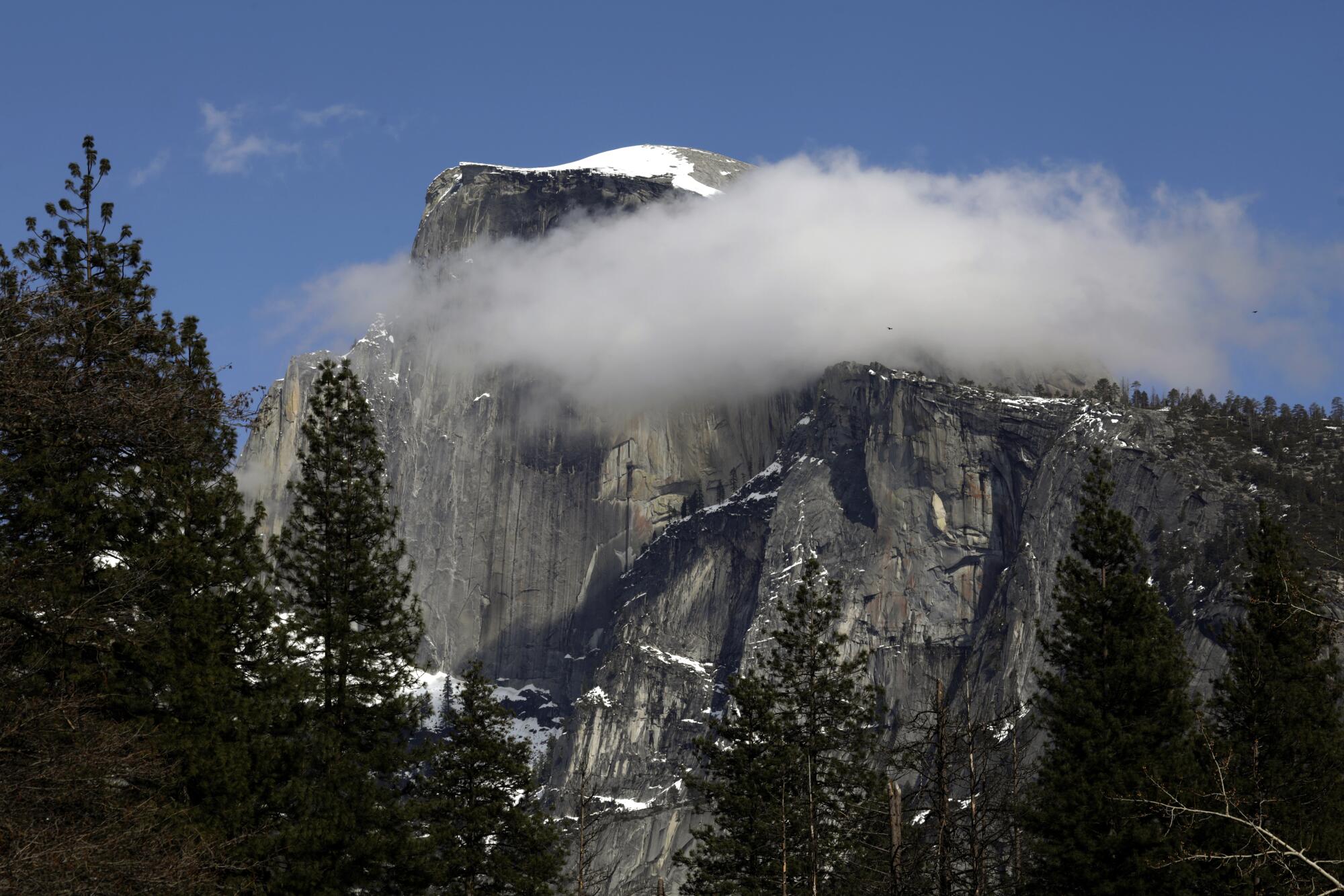 Clouds cover a portion of the cliffs at Yosemite's Half Dome.