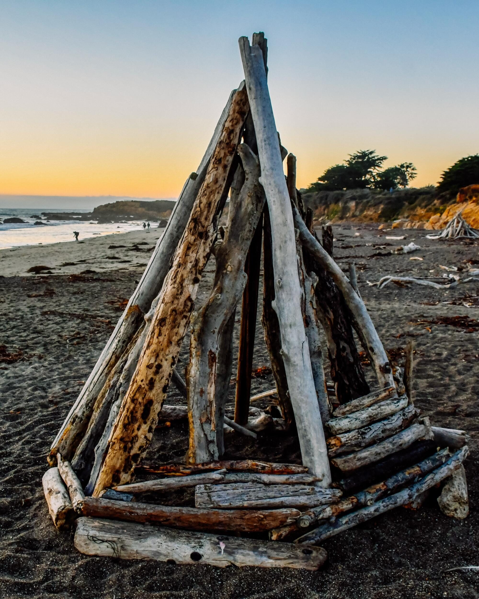 A conical driftwood sculpture on the beach at Cambria's Moonstone Beach.