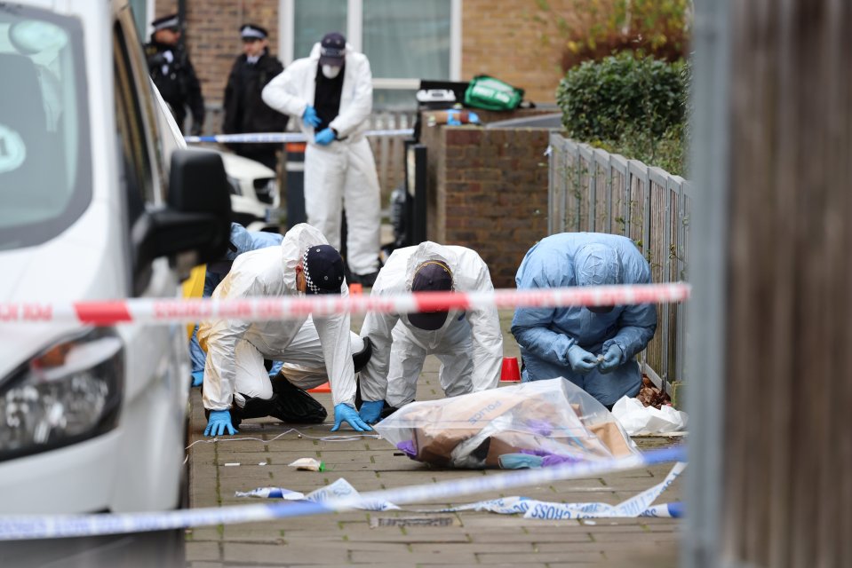 Forensic officers at a murder scene in Harlesden, London.