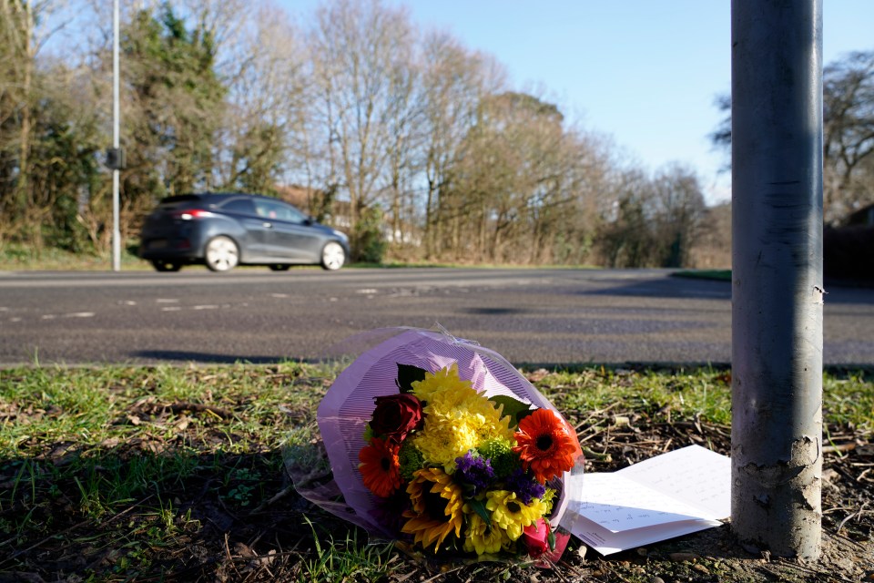 Flowers and a note left at a roadside following a fatal car accident.