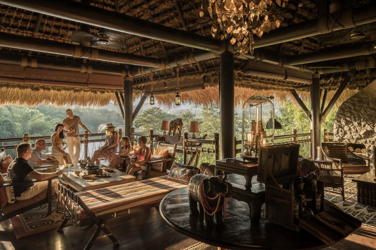 A group of people seated at a table under a large cabana.