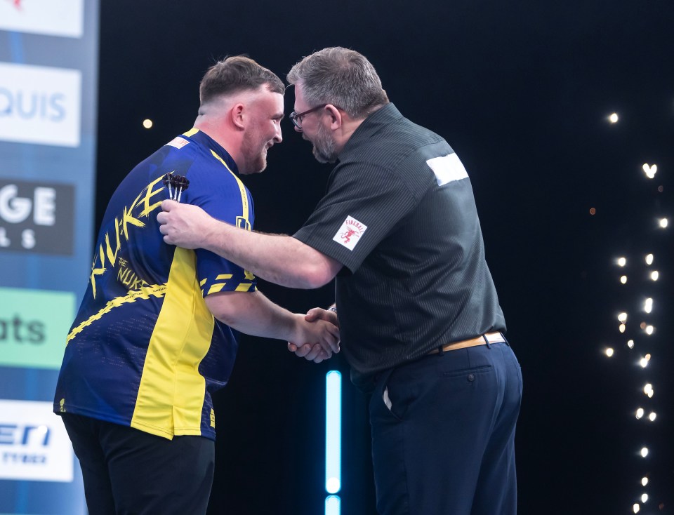 Luke Littler shaking hands with James Wade after a 4-0 victory.