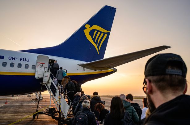 Passengers wait to board an aircraft of low cost Irish airline Ryanair at the Berlin-Brandenburg airport in Schoenefeld near Berlin