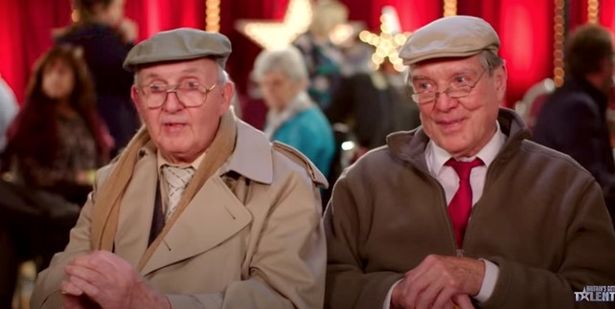 Henry and Malcolm in flat caps, white shirts and brown jackets