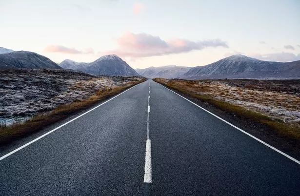 UK, Scotland, West Highlands, Glencoe, road leading into the distance in snow covered landscape