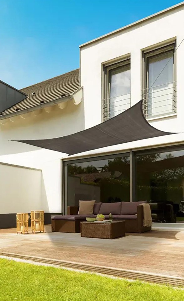 Grey triangular sun shade sail over patio furniture.