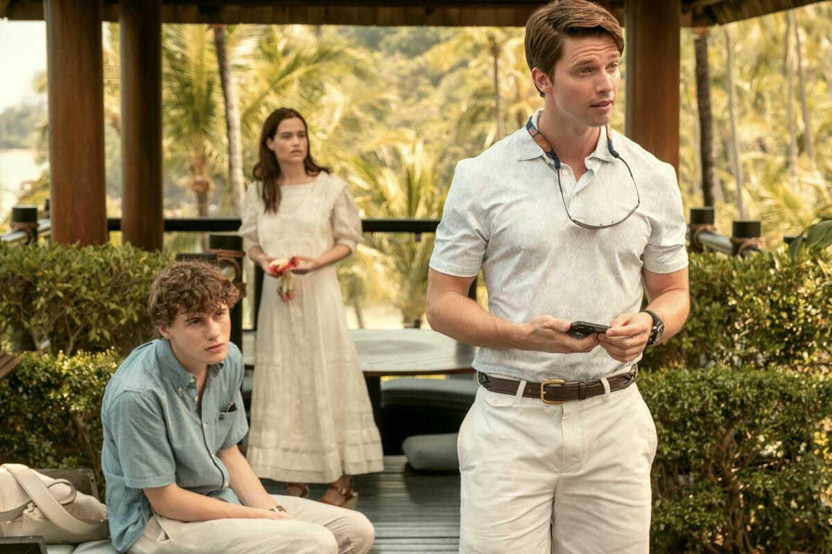 Three people standing on a patio.