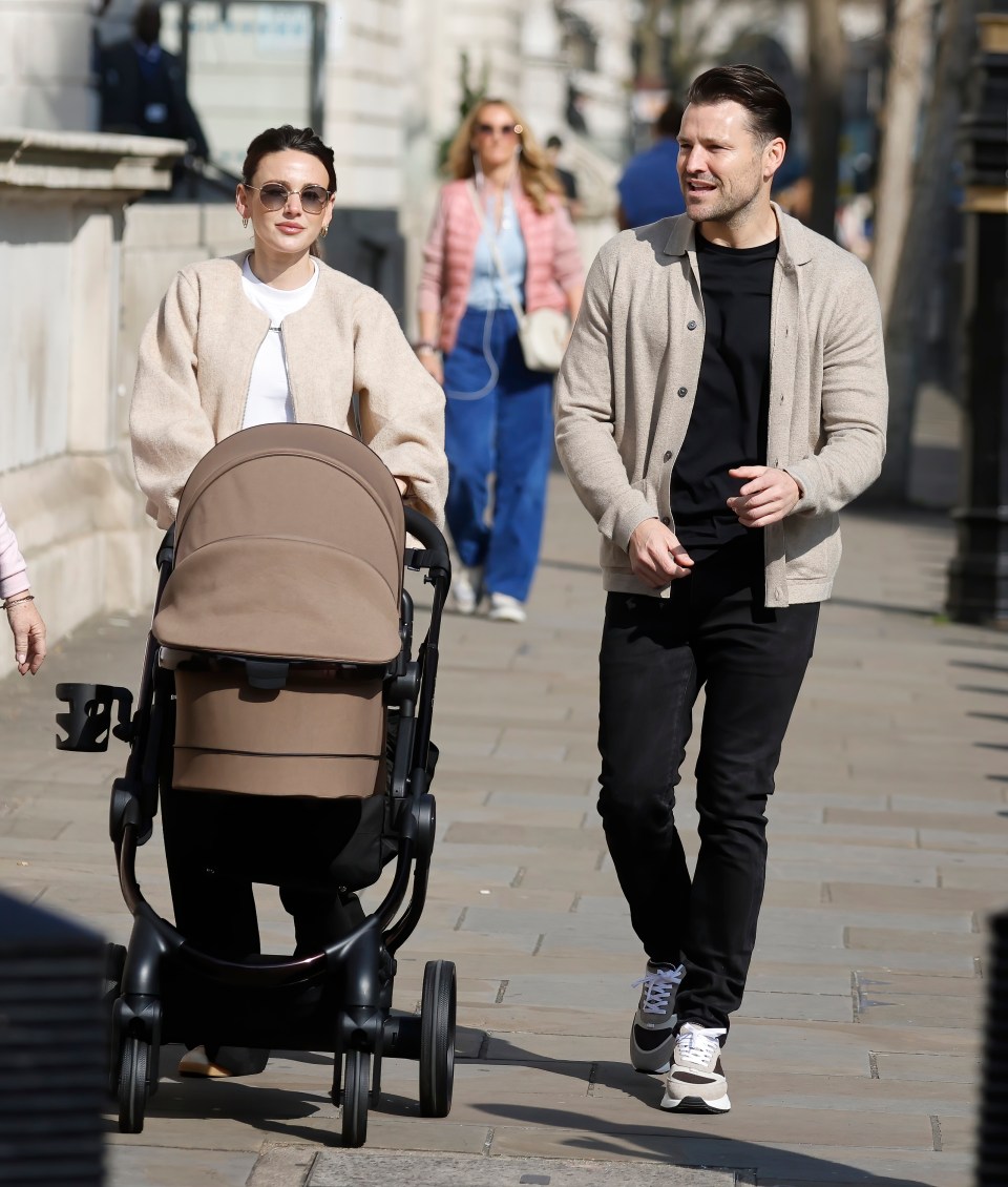 Mark Wright and Michelle Keegan strolling with their baby in a stroller.