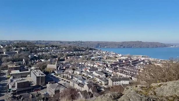 Aerial photo of Bangor, Wales, showing the sea to the right and rows of tiny houses on the left