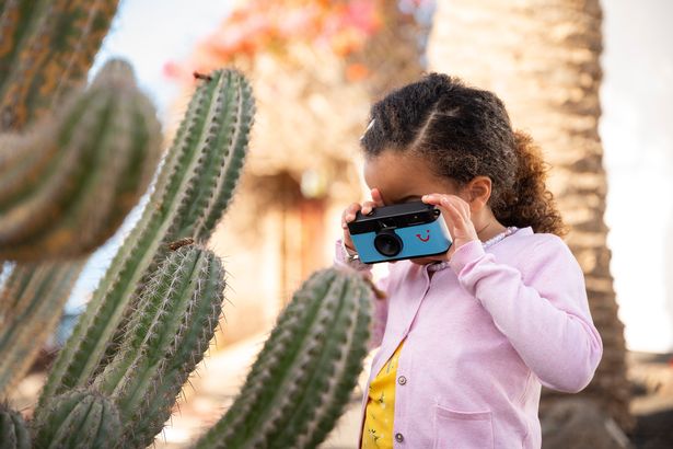 Kid trying out her camera at the 'Mini Memory Makers' photography masterclasses at TUI kids clubs