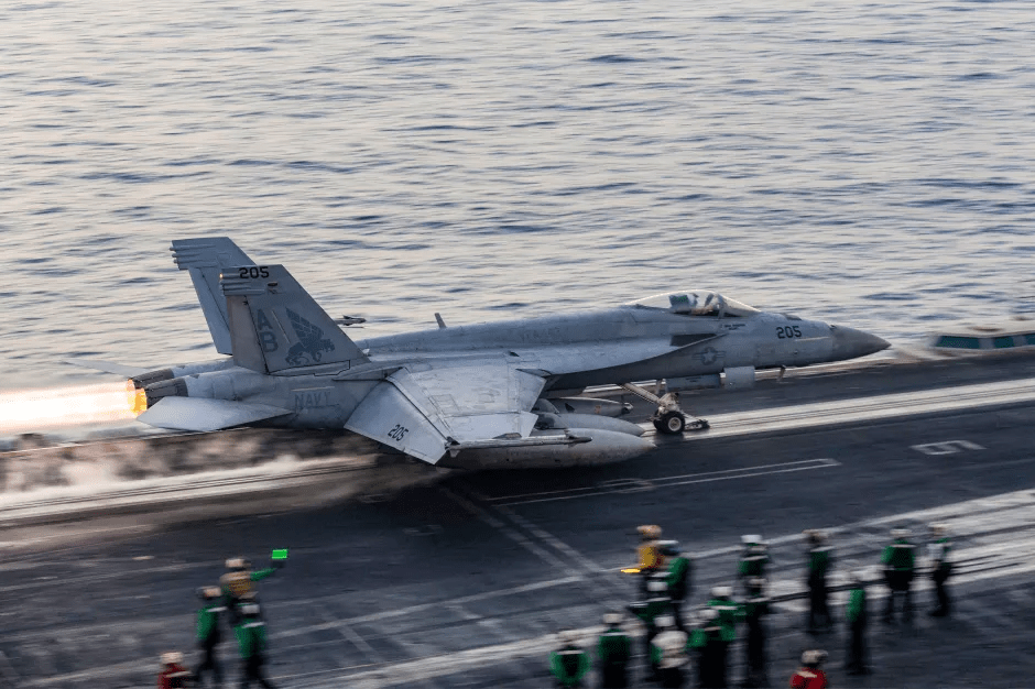 Navy fighter jet launching from aircraft carrier.