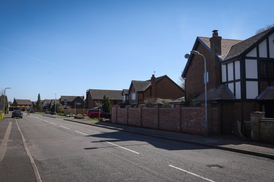 Residential street with newly built brick wall causing neighborhood dispute.