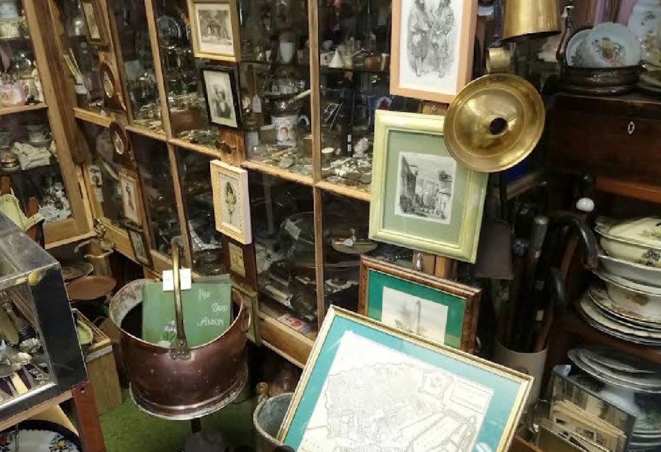Interior of an antique shop filled with framed pictures and various collectibles.