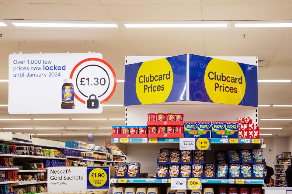 Tesco Clubcard prices and price-locked signs in a supermarket.