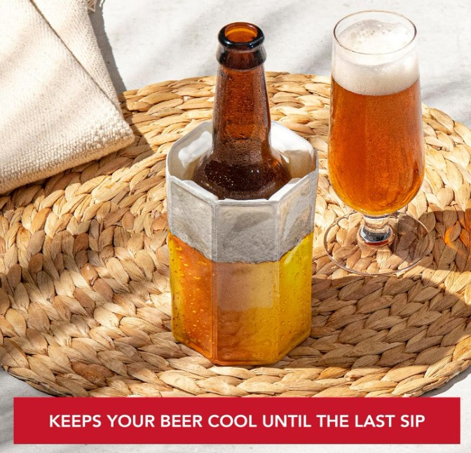Beer bottle in cooler, next to beer glass on woven mat.