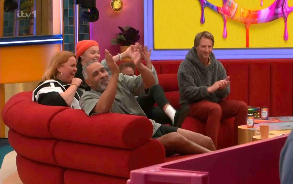 Housemates watching a contestant perform a rap.
