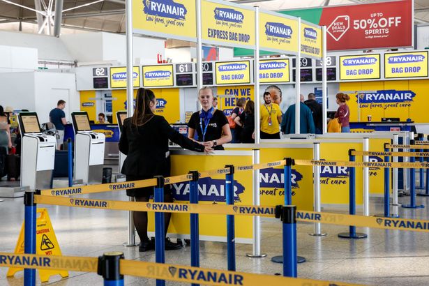 Passengers and staff at Ryanair airport check-in desks