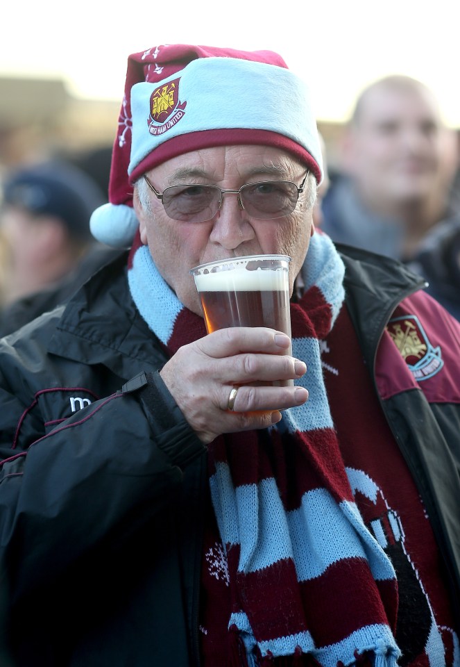 West Ham United fan in a Christmas hat drinking beer.