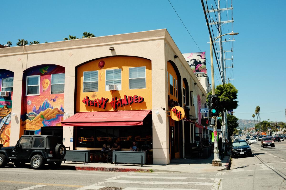 An exterior of Heavy Handed in Silver Lake. Beyond, the traffic and palm trees of Sunset Boulevard are visible.