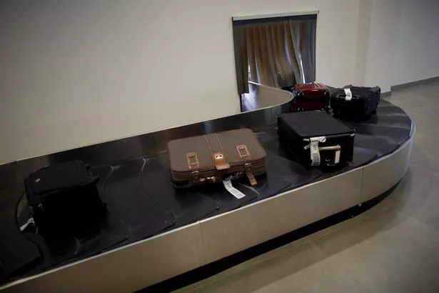 Image of checked bags on a luggage carousel 