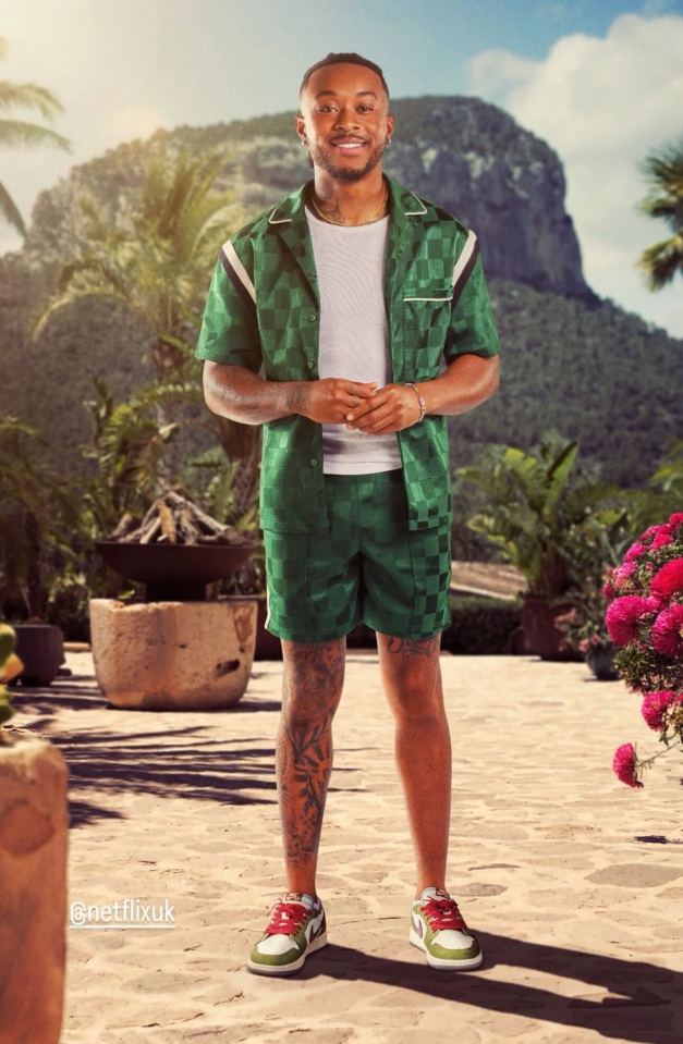 Man in green checkered shorts and shirt standing outdoors.