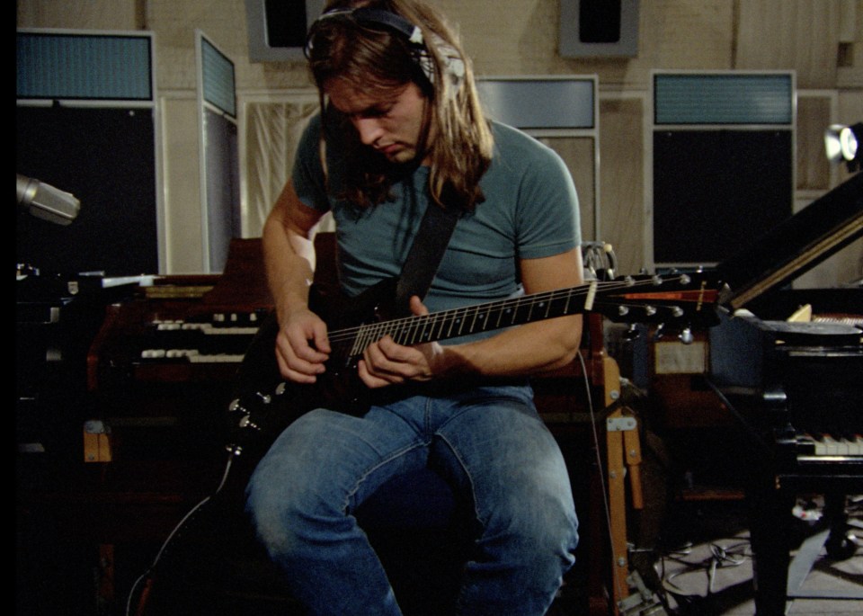 Pink Floyd's David Gilmour playing guitar in a recording studio.