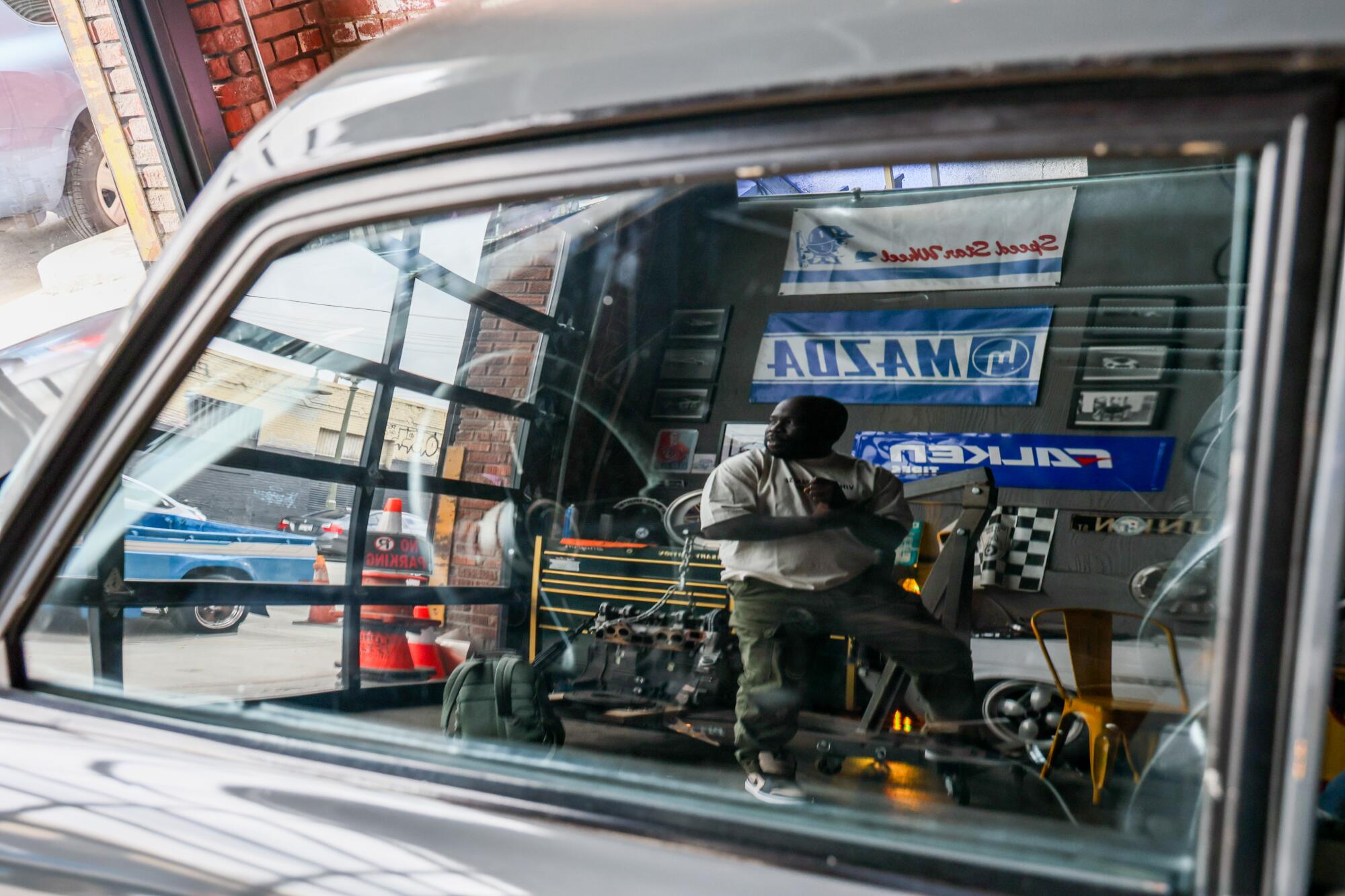 A reflection in a car window of Savant Young.