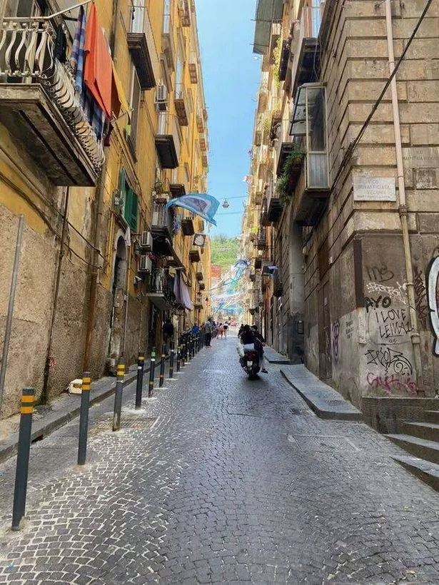 Photo of a moped zipping by the Spanish Quarter in Naples, Italy