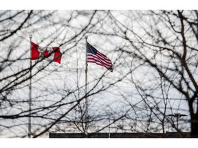 American and Canadian flags fly near the Peace Bridge at the Canada-US border in Fort Erie, Ontario. Donald Trump's threats and implementation of tariffs have weighed on the Canadian job market in recent months.