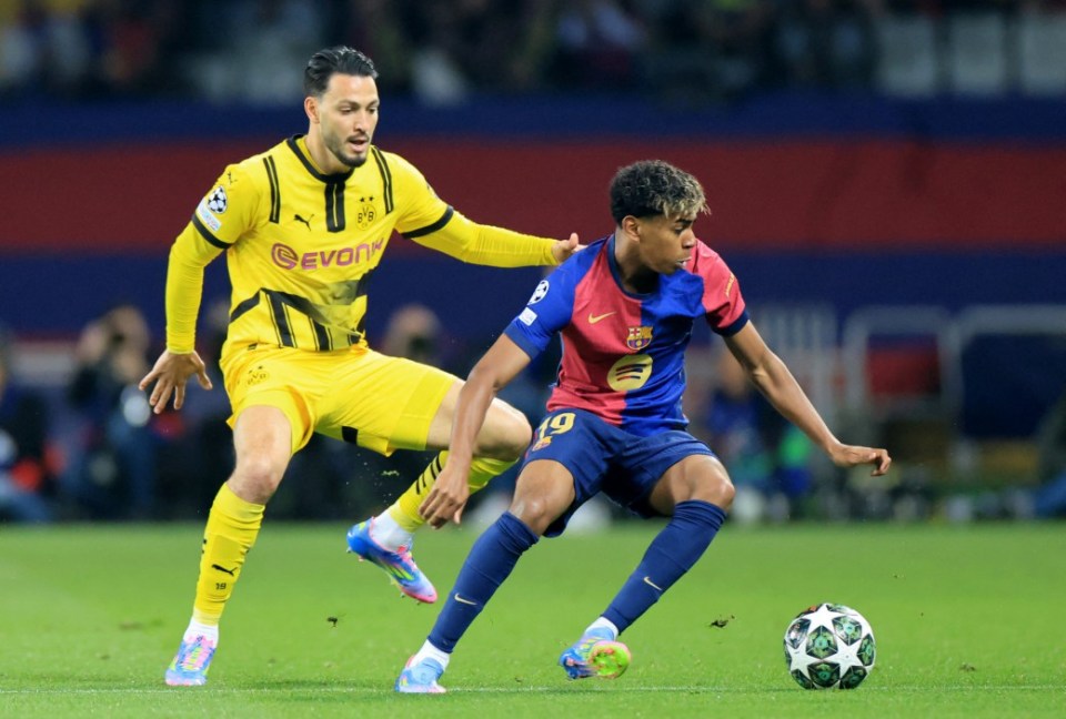 FC Barcelona's Lamine Yamal in action against Borussia Dortmund's Ramy Bensebaini.